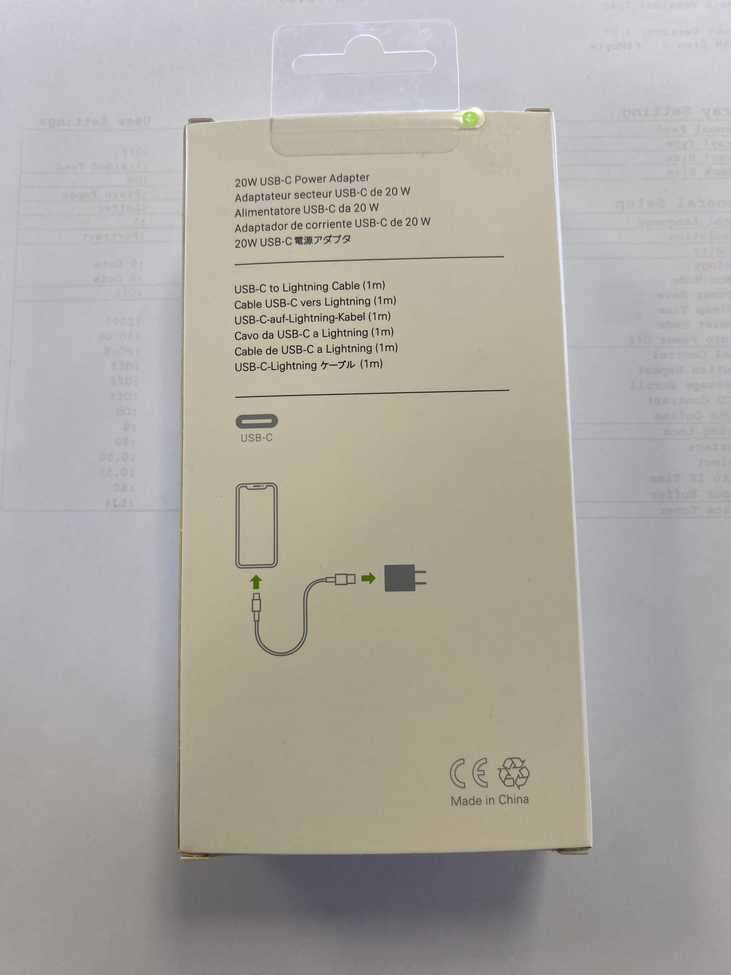 Beige power adapter packaging with text and diagrams on a white background